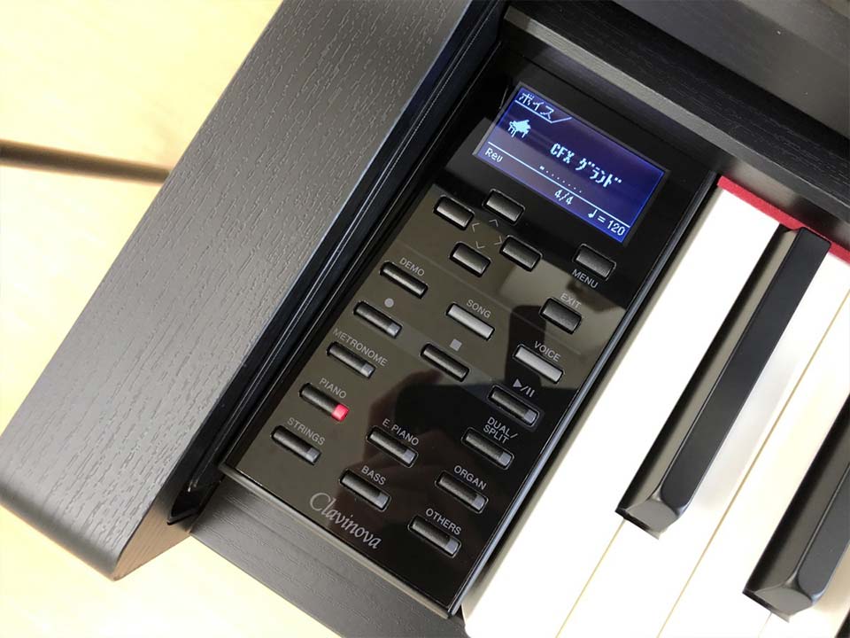 YAMAHA CLP-535 B đặt cạnh kệ sách và cây đàn guitar, thể hiện sự hòa hợp trong không gian sáng tạo